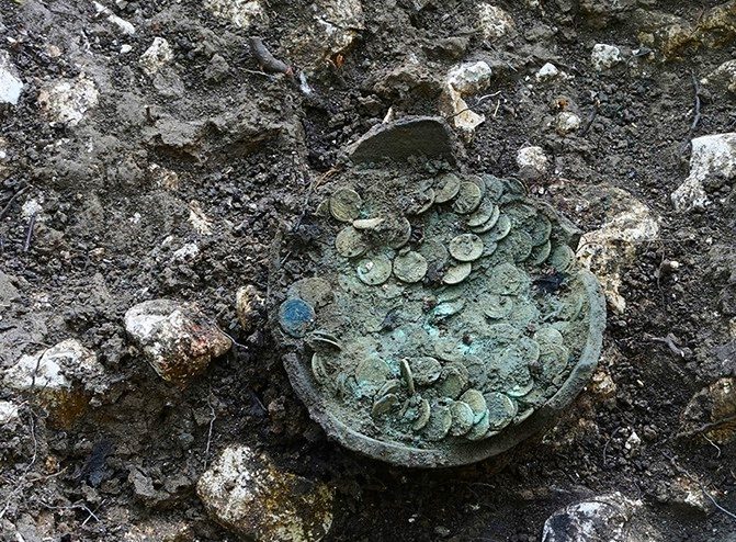 Volontario con il metal detector porta alla luce un vaso ricolmo di 1290 monete romane