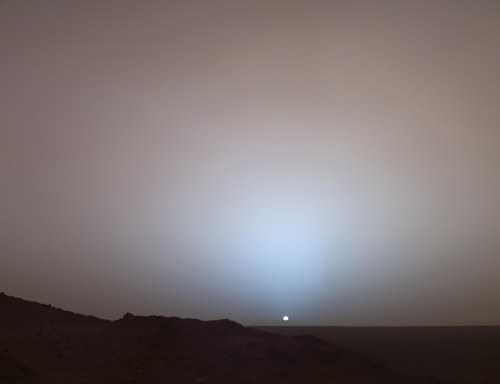 Ampia vista di un tramonto sopra il cratere Gusev scattata dal rover Spirit di NASA nel 2005. Sia l'aureola blu che il cielo rosa sono visibili.