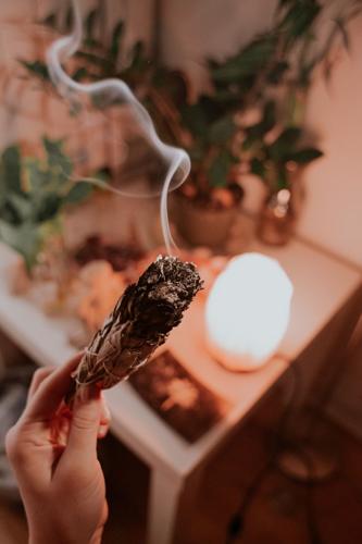 Mano che tiene un mazzo di salvia bruciante