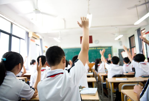 Mani alzate in classe di scuola media in Cina.