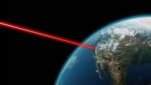 Un raggio laser rosso si propaga nello spazio da un satellite terrestre mostrando la California