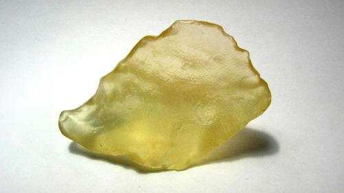 Un pezzo di vetro giallo su uno sfondo bianco