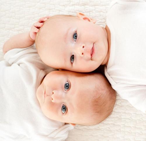 Due bambini che sono gemelli sdraiati.