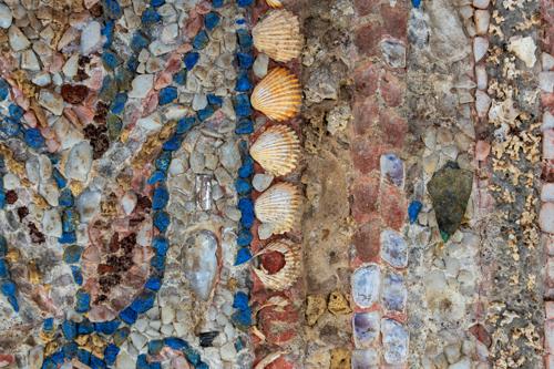 Un primo piano su un mosaico romano, mostrando i suoi sorprendenti dettagli con marmo, conchiglie marine e pietre rare.
