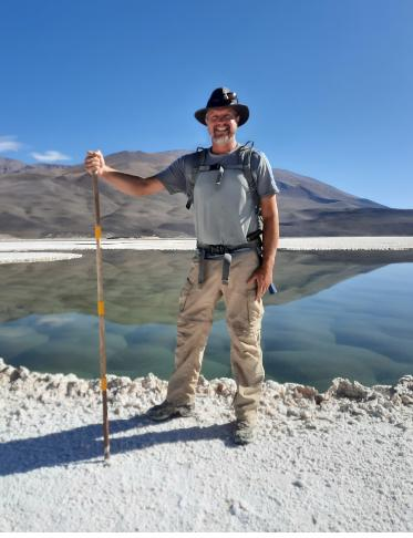 Brian Hynek in piedi di fronte a una laguna nella Puna de Atacama in Argentina, forse l'ecosistema sopravvissuto più vicino alle condizioni dei primi miliardi di anni della Terra, e forse dell'antica Marte