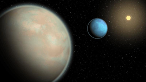 Rappresentazione artistica di due esopianeti ricchi di acqua con spesse atmosfere di foschia che orbitano attorno alla loro stella madre