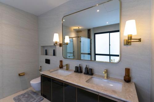 Moderno bagno di lusso con doppio lavabo e grande specchio a parete.