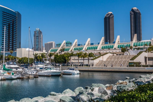 Centro congressi di San Diego visto dall'Embarcadero South. Edificio della conferenza di fronte a un porto con barche. Grandi edifici commerciali sullo sfondo.