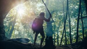 Neanderthals primordiali in piedi fuori da una caverna al mattino.