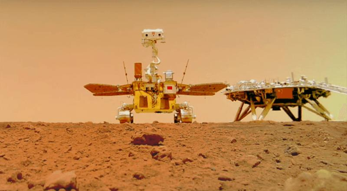 la foto mostra zhurong sulla superficie di Marte. A sinistra è visibile il lander