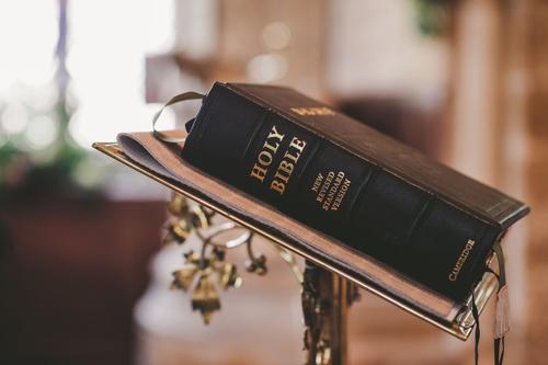 Una copia rilegata in nero della Bibbia su un supporto adornato con viti dorate