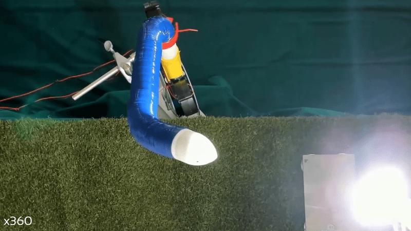 Robot blu e bianco che indica una lampadina su uno sfondo di erba finta