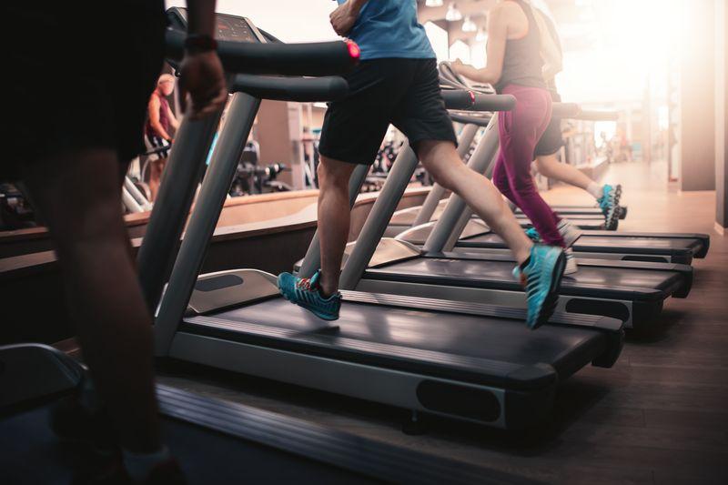 People running on treadmills at a gym