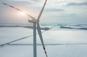 Tramonto sopra una turbina eolica nel campo d'inverno