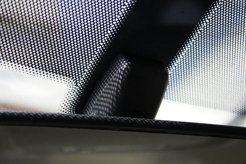 Specchietto retrovisore dell'auto e l'ombra dei punti dal vetro anteriore. Ombra a puntini. Raggi solari