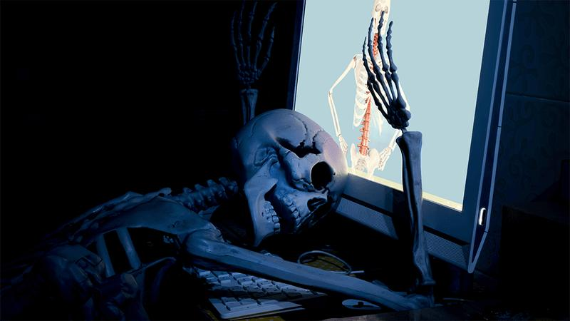 Uno scheletro di fronte a un computer.