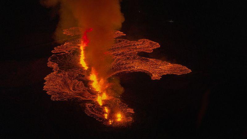 Il centro dell'immagine alta fontana di lava con fumo tutto il raffreddamento della lava è visibile intorno a terra in un pattern frattale