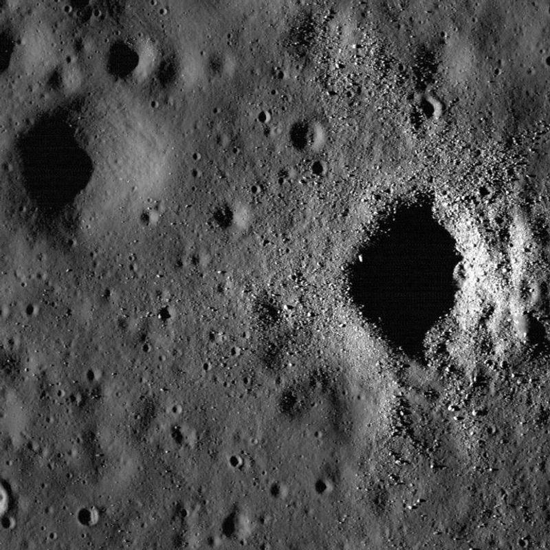 Un'immagine della luna. Una superficie grigia con poche protuberanze e due grandi crateri.
