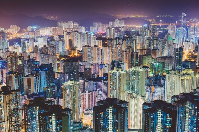 Decine di grattacieli e alti edifici illuminati lungo lo skyline di Hong Kong di notte in Cina.
