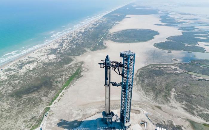 Il razzo è sul pad di lancio pronto a partire - il pad di lancio non è troppo lontano dal mare, dune e vegetazione a chiazze sono visibili