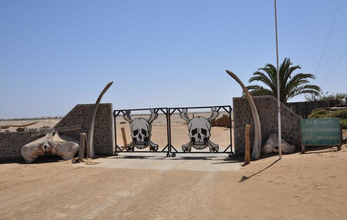 Ingresso meridionale al Parco Nazionale della Costa dello Scheletro, Namibia, con cancelli decorati come teschio e ossa di balena sbiancate ai lati