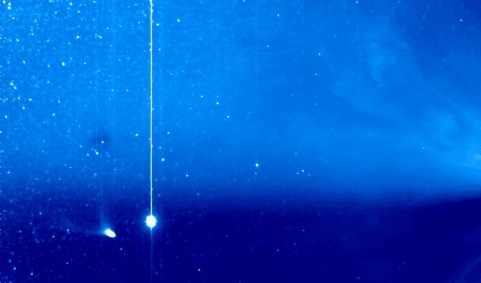 Cometa Pons-Brooks (in basso a sinistra) con la sua coda sul punto di staccarsi. Giove appare nelle vicinanze, mentre l'eiezione di massa coronale si sta avvolgendo attorno al Sole, che è fuori dalla vista a destra.