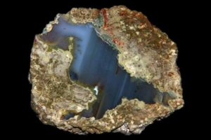 La parte esterna marrone e irregolare è riempita da uno strato blu lucente che appare diagonalmente attraverso la roccia.