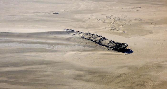 nave naufragata fotografata dall'alto, parzialmente coperta di sabbia