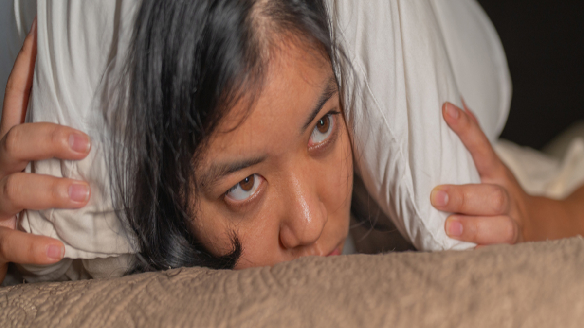 WomenLyingDownHoldingPillowOverEars-1-1.jpg