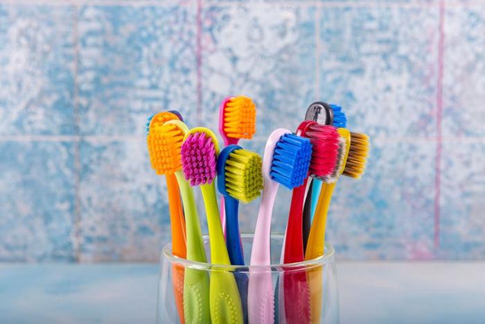 colourful-toothbrushes-in-a-glass-container-in-a-bathroom-m-1.jpg