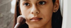 Una giovane donna che si trucca con un pennello
