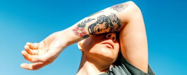 PersonShieldsEyesWithTattooedArm-642x260-1-1.jpg