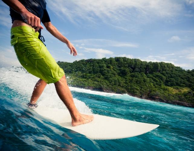Parte inferiore del corpo di una persona visibile su una tavola da surf
