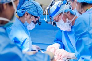 quattro chirurghi indossano maschere e altri indumenti chirurgici durante un'operazione di trapianto