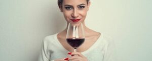 donna che tiene un bicchiere di vino rosso