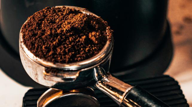 macinatura del caffè nella testa di un gruppo di una macchina per espresso