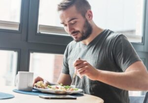 uomo che mangia insalata