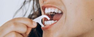 Una donna che usa il filo interdentale