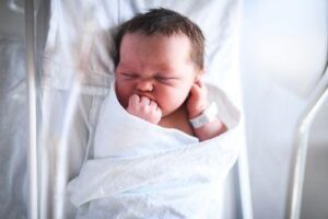 un neonato sdraiato in una culla d'ospedale