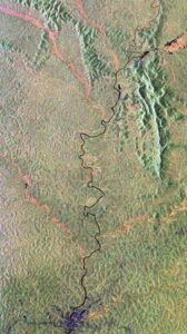 Il fiume è visto scorrere attraverso una fitta foresta pluviale con affluenti tracciati da una vegetazione più bassa visibile in rosso.