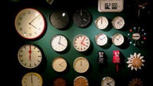 Un gruppo di orologi su una parete verde.