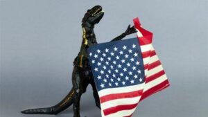 Giocattolo di dinosauro di plastica che tiene la bandiera degli Stati Uniti