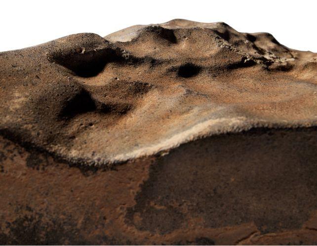 un primo piano della roccia marziana rosso-brunastra che mostra la sua superficie abbastanza liscia