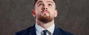 uomo in giacca che guarda in alto