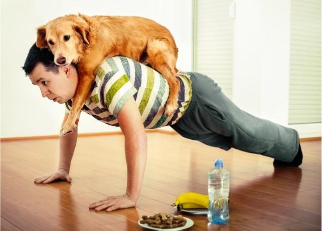 Uomo che fa flessioni con un cane sulla schiena