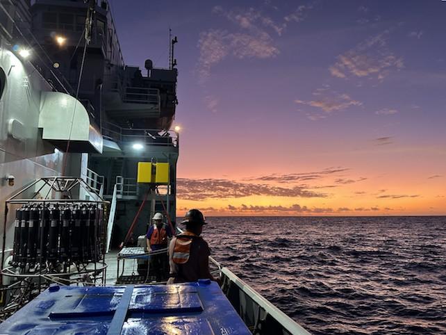 Una vista del tramonto dalla nave da ricerca Thomas G. Thompson mentre trasporta attrezzature per il monitoraggio dei cianobatteri fotosintetici.