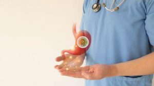 Medico che mostra l'infezione da batteri Helicobacter pylori in uno stomaco umano.