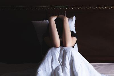 Donna seduta a letto.