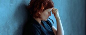 donna depressa contro un muro di cemento