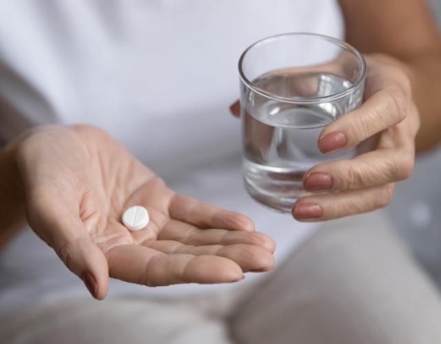 Primo piano di una donna anziana che prende le medicine